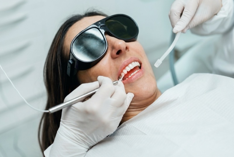 Patiente en soin parodontal au laser diode, avec lunettes de protection, chez Clear Smile