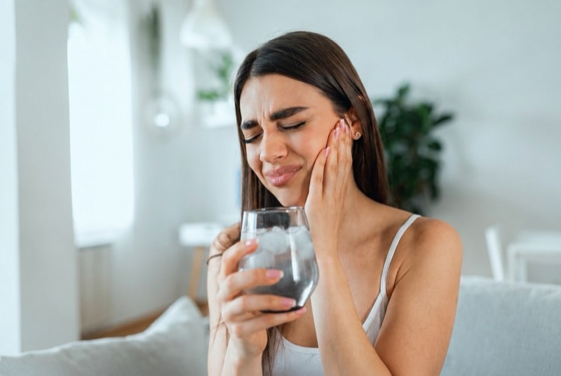 Personne souffrant d'une douleur dentaire, tenant sa joue